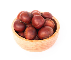 Obraz premium Closeup horse chestnuts in wood bowl isolated on white background, healthy food concept