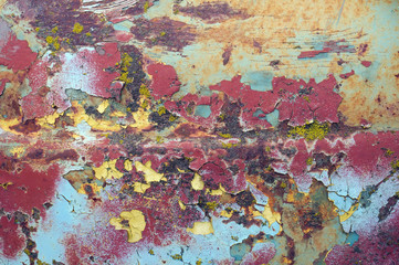 Enamelled  cracked  surface of the hood of the old car was painted in yellow blue and red colors