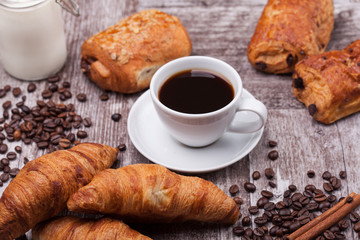 Breakfast with fresh coissants with coffe and milk on rustic wooden table