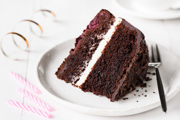 Dark chocolate cake, birthday cake on white plate. Closeup view