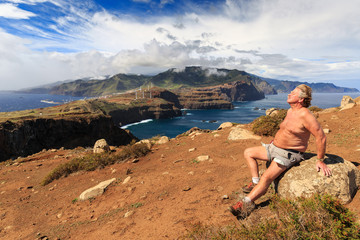 Fototapeta premium Tourist on the cliffs in the beautiful landscape of the east coast of the island Madeira at Ponta de Sao Lourenco nature reserve
