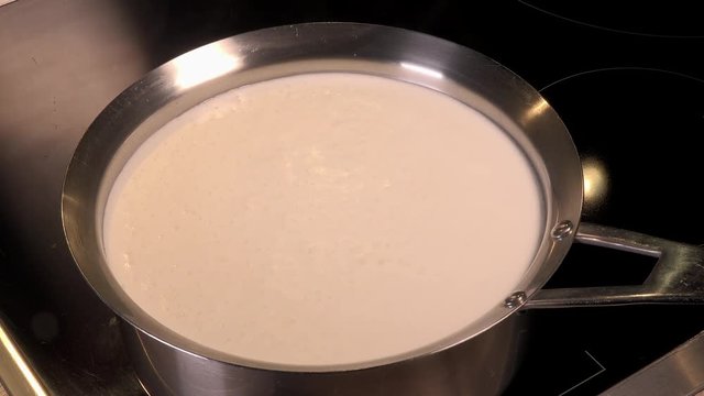 Cook natural organic milk, boil the milk in pots, milk that is about to overflow, overflowing milk