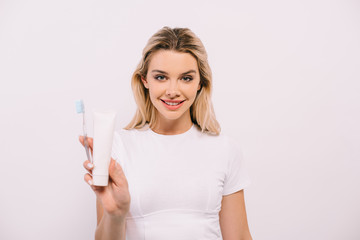beautiful woman holding toothbrush and toothpaste with copy space isolated on white