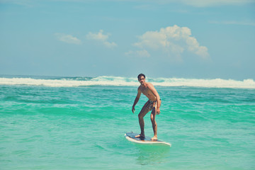 Surfer man with surfboard enjoying on the beach. Summer concept.