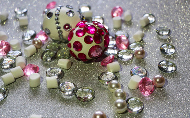 Easter composition flatlay. Easter eggs decorated with shiny rhinestones on  silver background with glass ornaments and pearl beads.