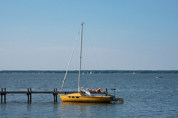 Women tanning in the summer sun on the pier at lake Steinhuder Meer