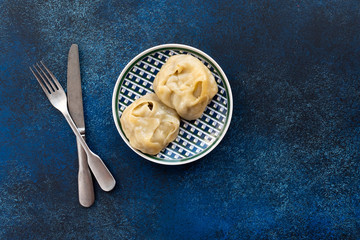 Traditional manti food on plate on blue background, top view
