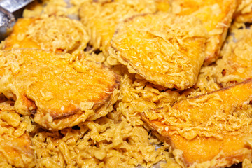 Traditional Asian freshly fried puff pastries in a street vending tray. Close-up