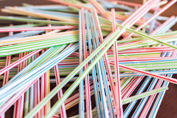 Colorful drinking straws on wooden table 