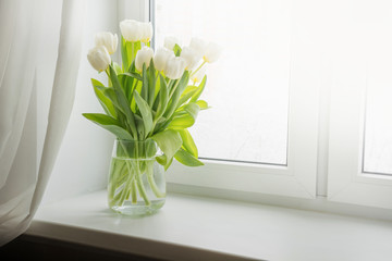 Bouquet of white tulip on windowsill. Copy space. - obrazy, fototapety, plakaty