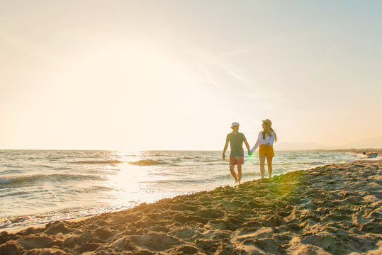 Happy Romantic Middle Aged Couple Enjoying Beautiful Sunset Walk on the Beach. Travel Vacation Retirement Lifestyle Concept