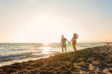 Happy Romantic Middle Aged Couple Enjoying Beautiful Sunset Walk on the Beach. Travel Vacation Retirement Lifestyle Concept