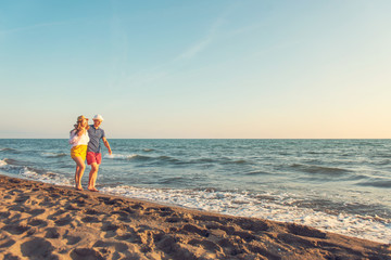 Happy Romantic Middle Aged Couple Enjoying Beautiful Sunset Walk on the Beach. Travel Vacation Retirement Lifestyle Concept