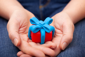 Woman holds gift wrapped with blue ribbon