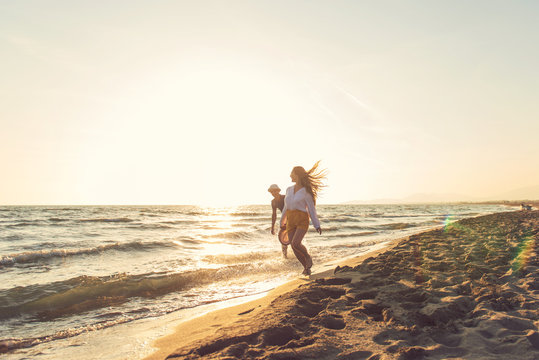 Happy Romantic Middle Aged Couple Enjoying Beautiful Sunset Walk on the Beach. Travel Vacation Retirement Lifestyle Concept