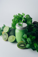 Green detox healthy smoothie from green fruit - avocado, salad, kale, lime, kiwi, mint. Alkaline diet concept. Vegan healthy alkaline food. Green fruit background. Flat lay