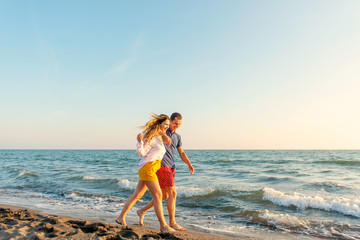 Happy Romantic Middle Aged Couple Enjoying Beautiful Sunset Walk on the Beach. Travel Vacation Retirement Lifestyle Concept