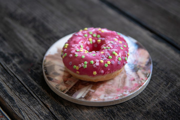 Homemade pink glazed donuts on old wooden table