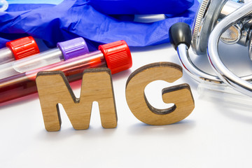 MG abbreviature mean Magnesium electrolyte with lab tubes with blood and stethoscope. Using acronym...