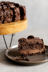 Prague chocolate cake on gray plate. Cake on wooden stand