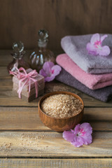 Obraz na płótnie Canvas Sea salt, natural handmade soap, natural cosmetic oil and colorful towels with azalea flowers on rustic wooden background