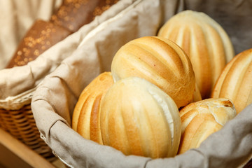 Fresh white  buns in basket in bakery