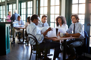 Business Team Having Informal Meeting Around Table In Coffee Shop