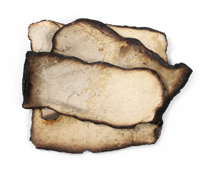 Burned and charred paper scraps isolated on white background, top view