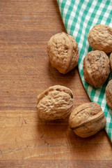 Walnuts on wooden background and green and white checkered cloth