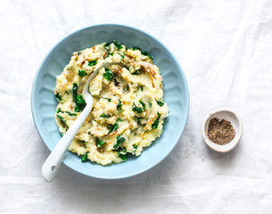Mashed potatoes with spinach and crispy fried onions on a light background, top view. Delicious...