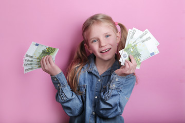 business and money concept - happy little girl with euro cash money over pink background