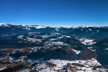 Winter landscape with mountain range covered in snow and pine forests