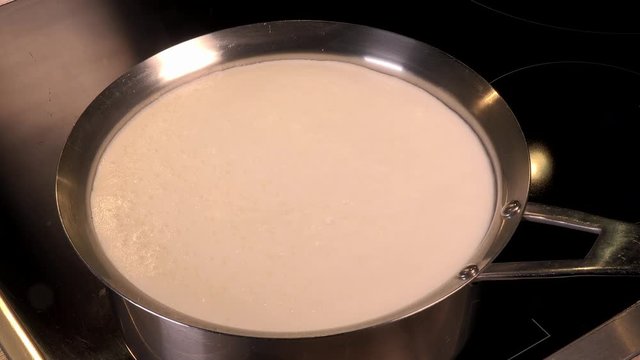 Cook natural organic milk, boil the milk in pots, milk that is about to overflow, overflowing milk