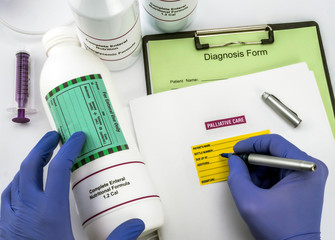 Nurse writing data sick, enteral nutrition palliative care in hospital, conceptual image,...
