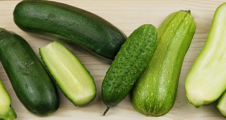 Zucchini, squash and cucumber are lying on the cutting board