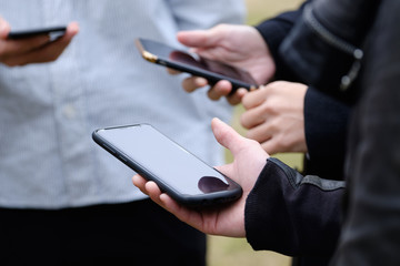 屋外でスマホゲーム・アドレス交換をする人々