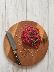 Sliced raw meat on a wooden board. 