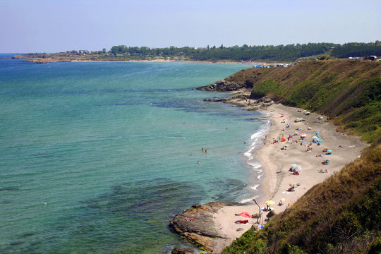 Black Sea, Bulgaria. Sunny summer day. Tourists on a wild beach off the coast of a peaceful bay. It is shot from above.