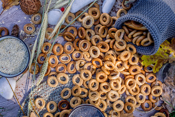 Flat lay with a lot of bagels on the wooden background and in a knitted bag.