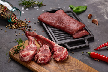 Meat Raw Fresh Mutton on the bone Spices Chesno and Rosemary on a black background