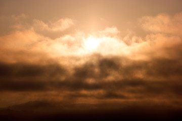 Cloudy sky at dawn. Colorful scenic landscape with mountains, yellow and orange sky with clouds. Morning sunrise in mountains.