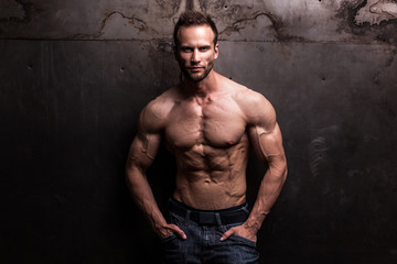 strong athletic man on dark grunge background