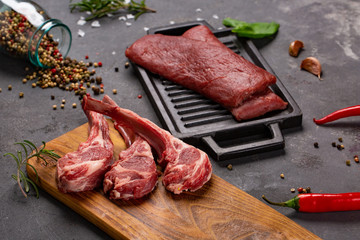 Meat Raw Fresh Mutton on the bone Spices Chesno and Rosemary on a black background