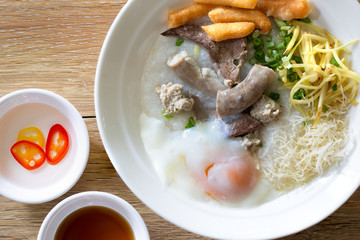 Rice congee delicious asian breakfast food in white bowl and ingredient