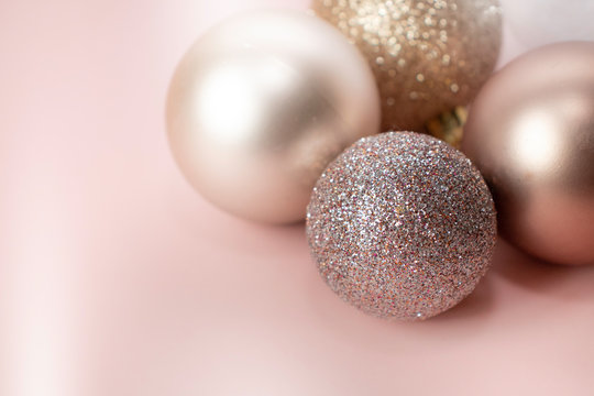 Rose Gold Christmas Baubles On A White And Pink Background