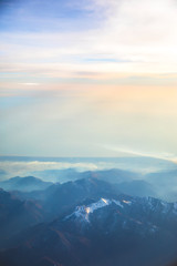 Obraz premium Aerial view over the Mediterranean sea and blue Alps Mountains with soft sunset light