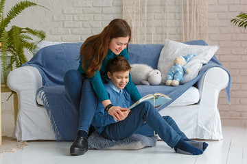 Photo session - friendly family. Brother and sister are reading a book.