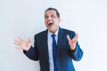 Middle age business man celebrating and screaming happy for succesful win