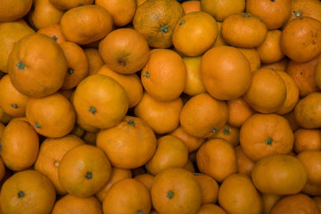Many small ripe juicy mandarins in the box. Background