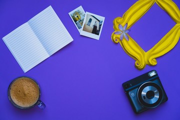 Purple background yellow frame notebook pen coffee mug globe flower flat lay instant photography camera keyboard computer 